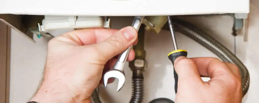 Boiler repair technician tightening pipe fittings and connections in Knoxville, TN