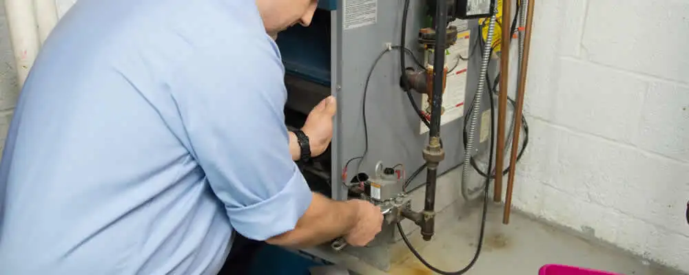 Furnace repair technician inspecting and servicing a home heating system in Knoxville, TN