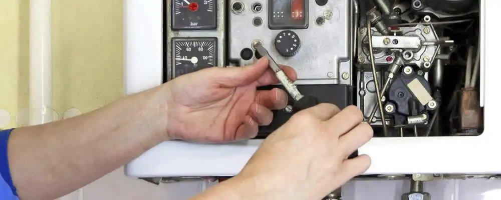 Heating repair technician adjusting boiler controls and components in Knoxville, TN