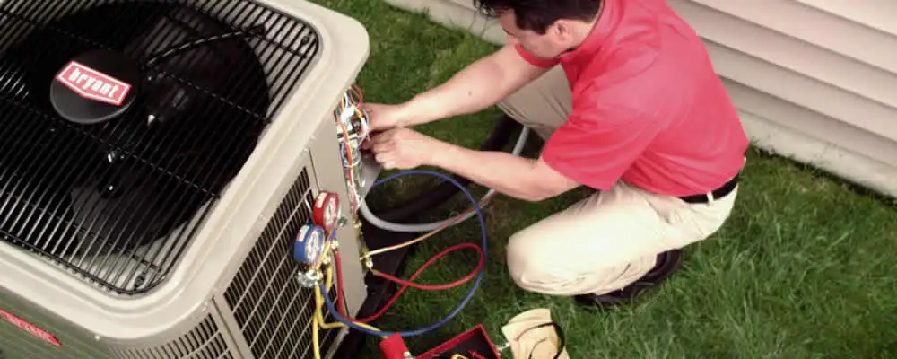 HVAC technician servicing an outdoor air conditioner unit in Knoxville, TN
