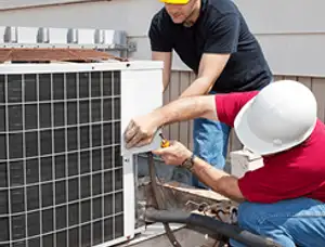 HVAC technicians repairing an outdoor AC unit on a rooftop in Knoxville, TN
