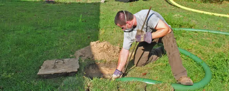 Septic pumping technician servicing a residential septic tank in Knoxville, TN