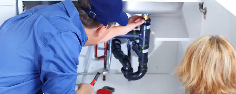 Plumber repairing under-sink drain pipes and fittings in Knoxville, TN